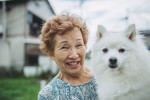 Un Spitz Japonais dans les bras d'une femme âgée